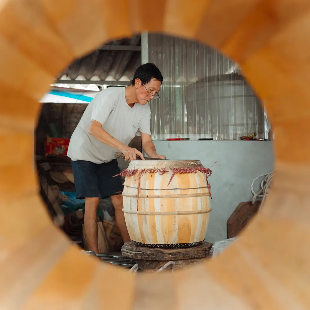Casco de tambor de duelas de madera clara en un taller, sujeto con aros de tensión provisionales